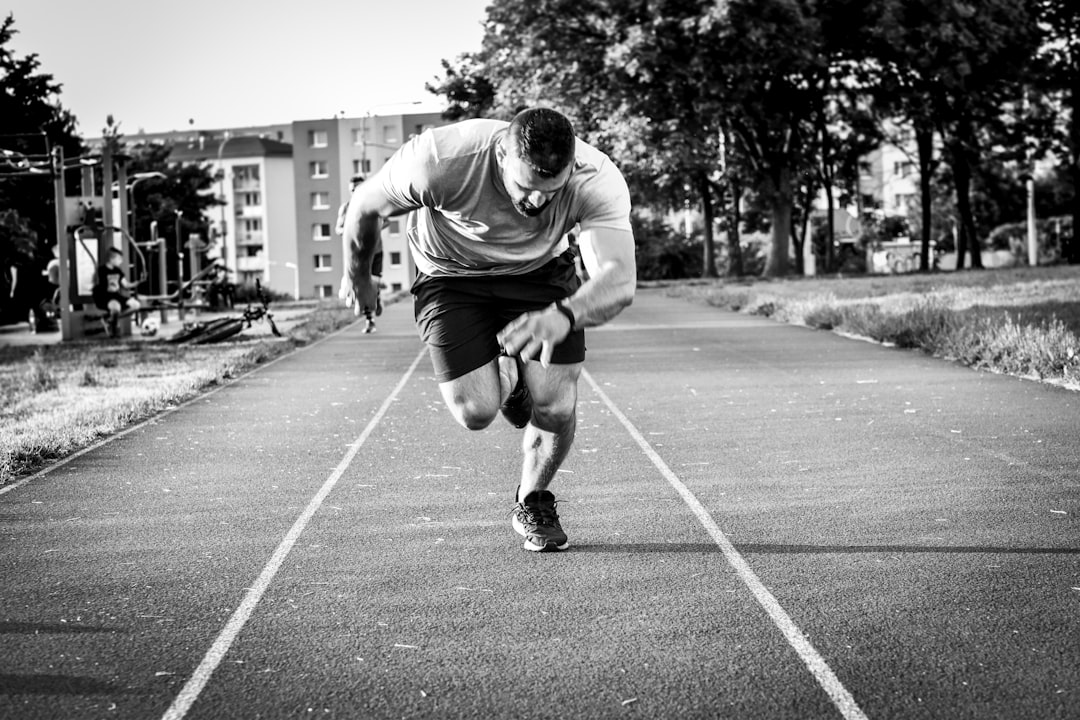man-in-gray-long-sleeve-shirt-and-black-shorts-running-on-road-during-daytime-csc6s3m9ud0
